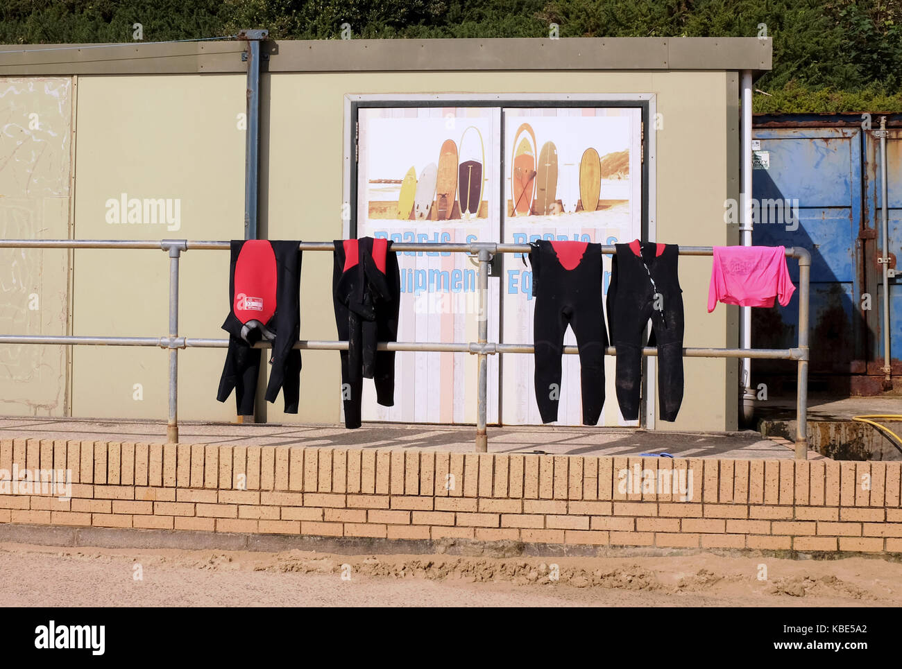 Bournemouth September 2017 - Wetsuits hanging out to dry at surf equiptment hire shop Boscombe Stock Photo