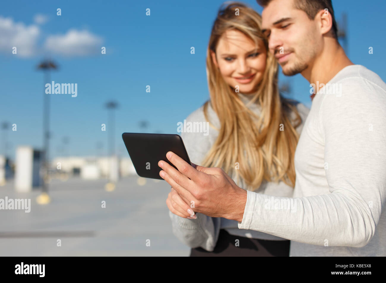 Young casual couple browsing internet by tablet outdoor, depth of field Stock Photo