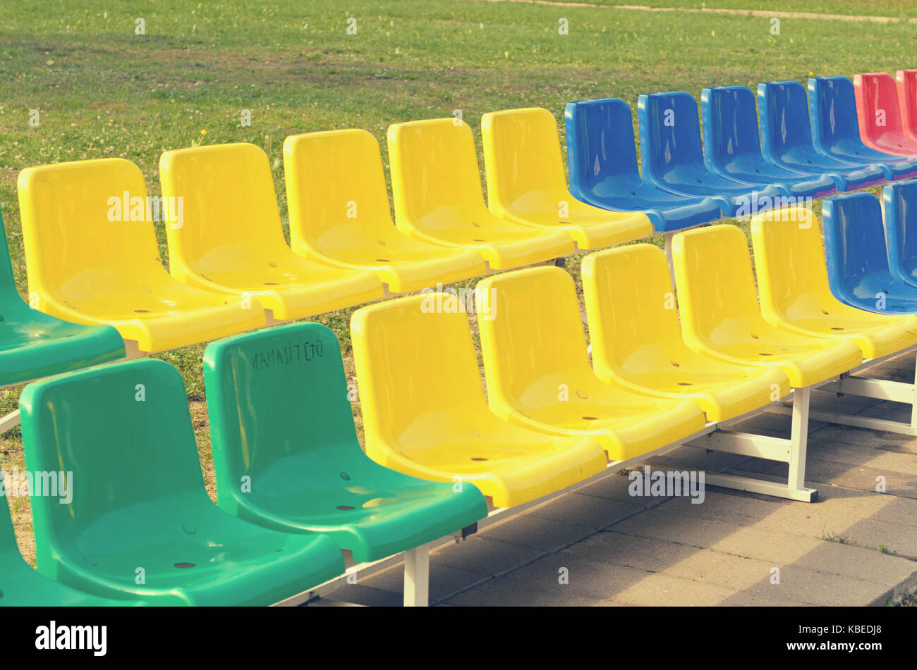 Multicolored benches for sports fans standing in two rows Stock Photo