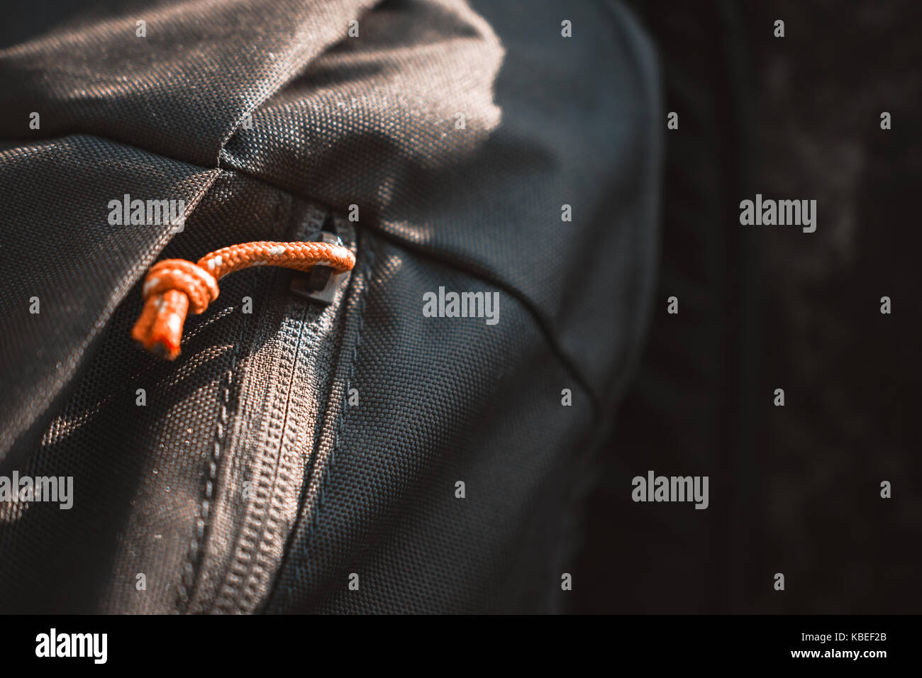 Close-Up Of Olive Green Backpack With Orange Zipper Placed On A Rock Stock Photo