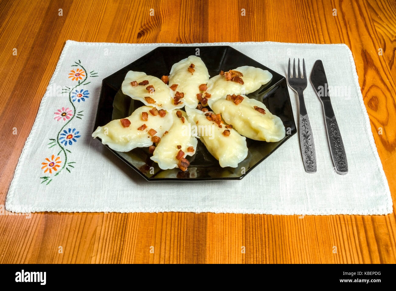 Cooked dumplings with cheese pork scratching on wooden table. Polish