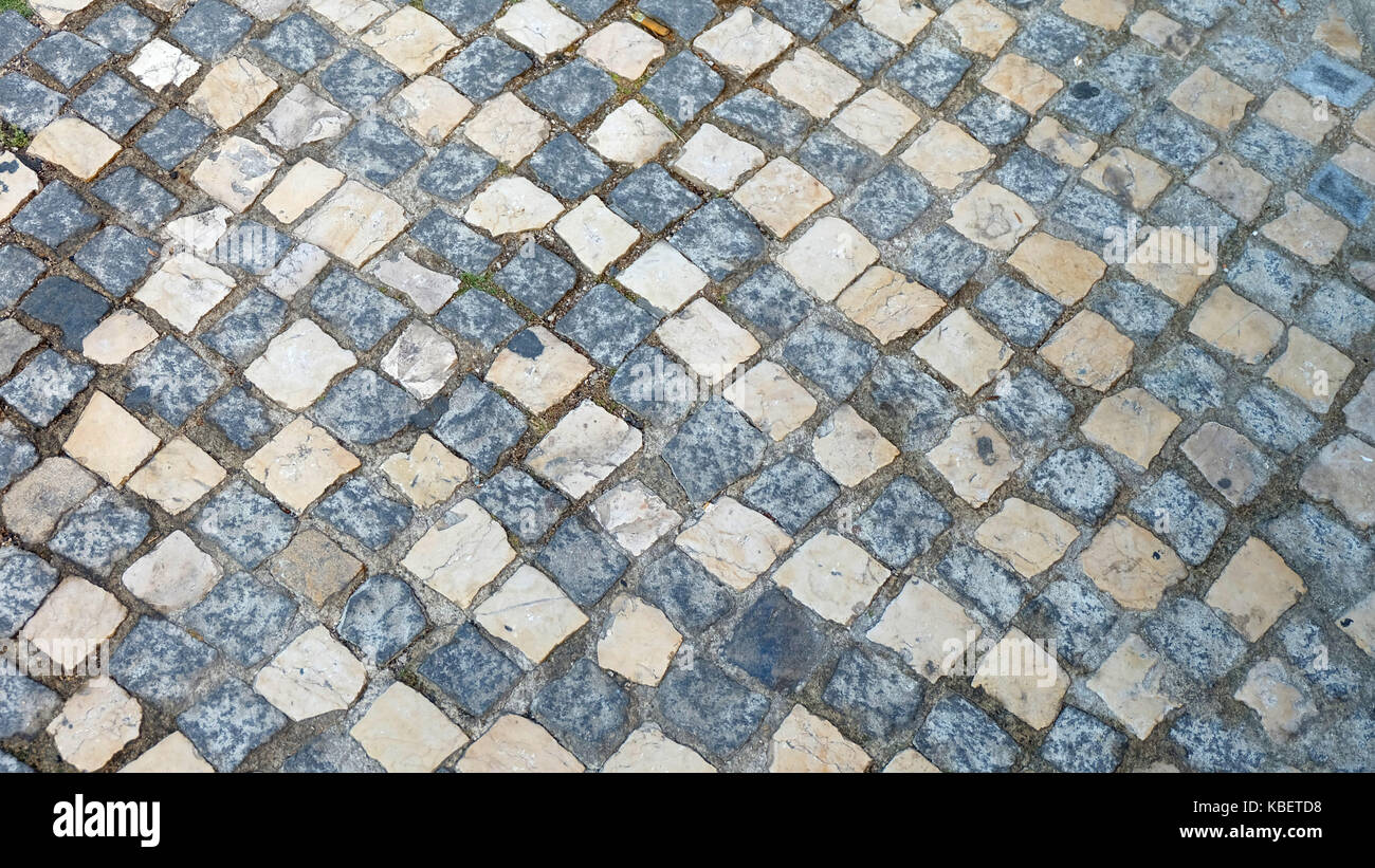 Portuguese pavement in contrast color. A traditional and classic pavement style made from many small flat pieces of stones. Stock Photo
