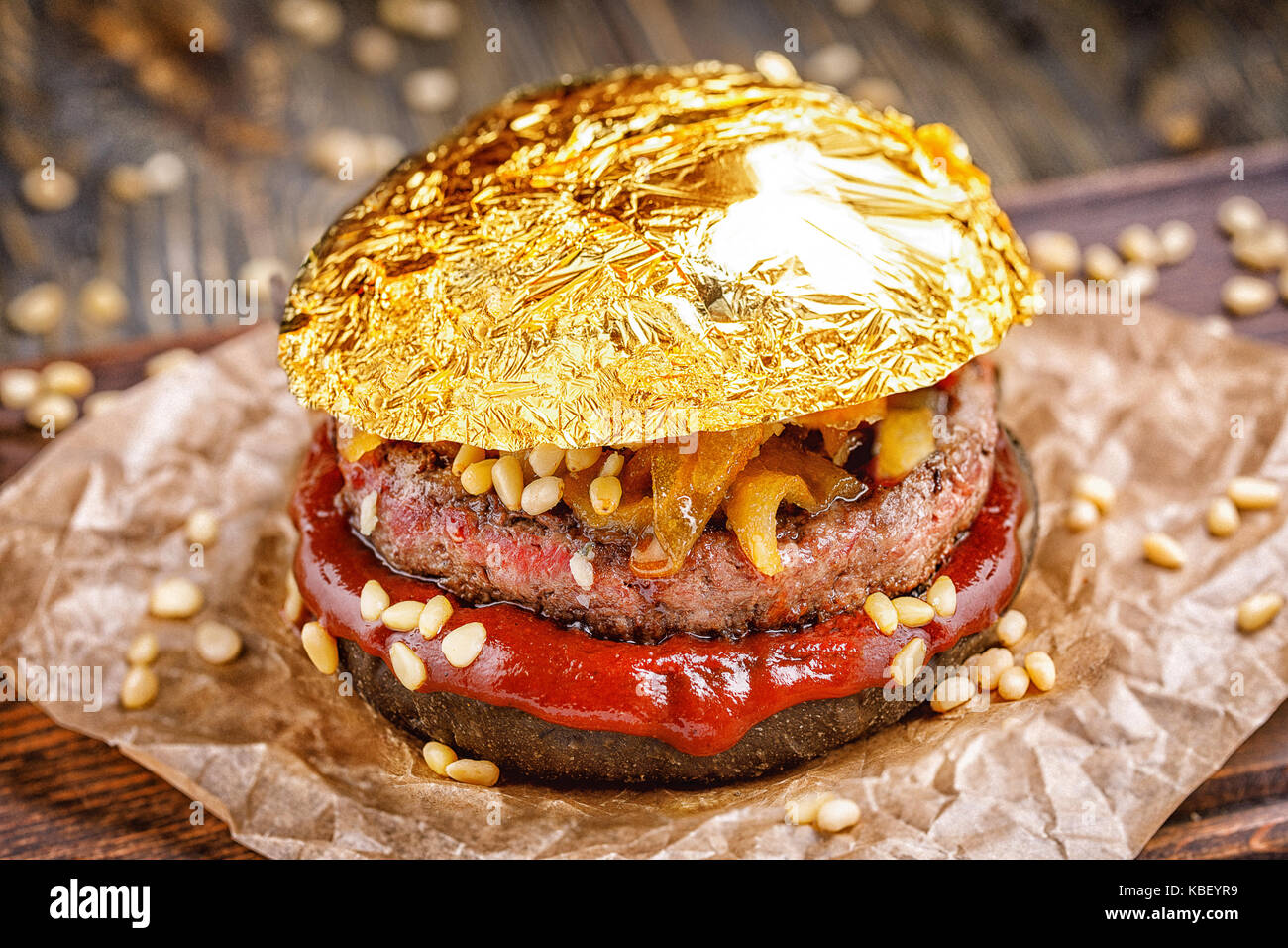 Gold beef burger with a black bun,with arugula and cheese and ketchup