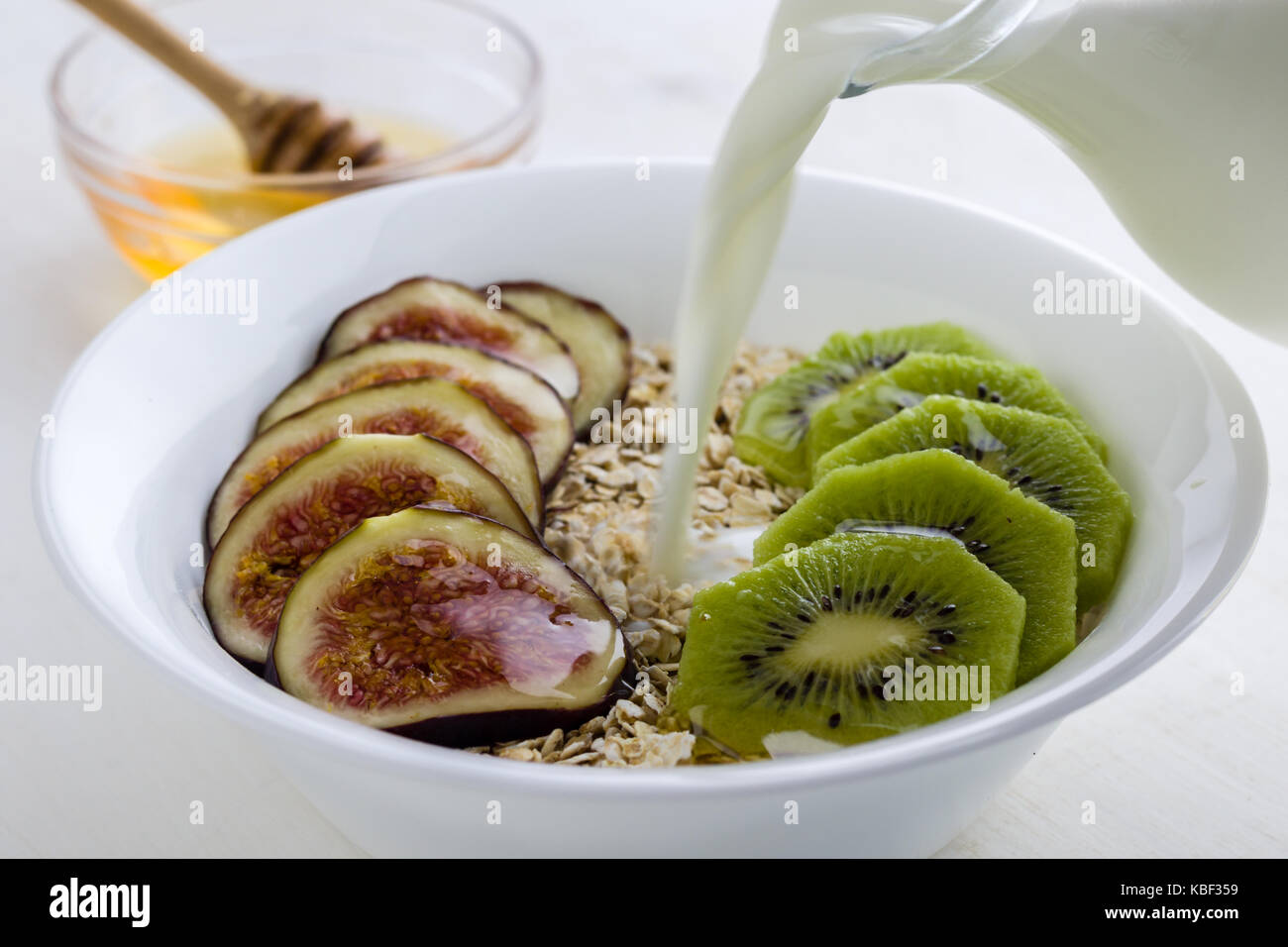 figs and kiwi muesli with honey in white bowl Stock Photo Alamy