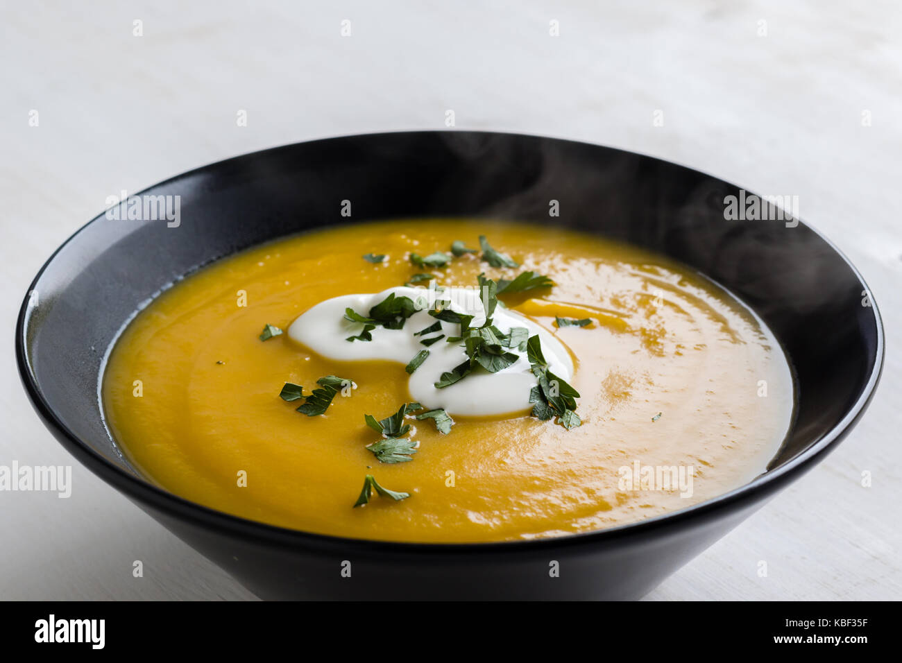 healthy vegetarian pumpkin cream soup in black bowl Stock Photo