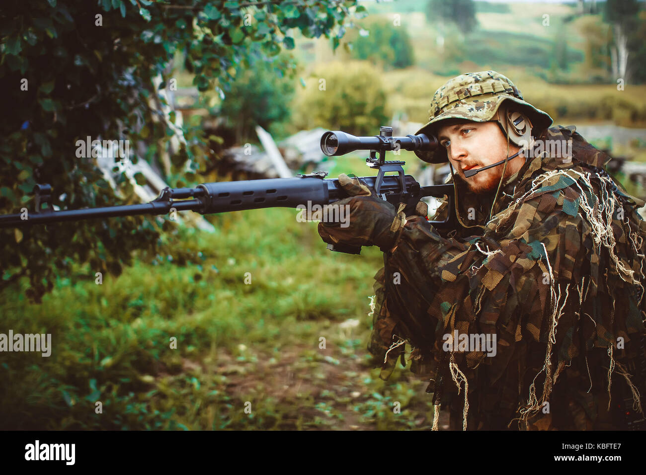 a man in military uniform with weapon in nature Stock Photo
