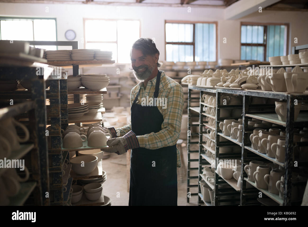 Female potter painting bowl in pottery workshop Stock Photo - Alamy