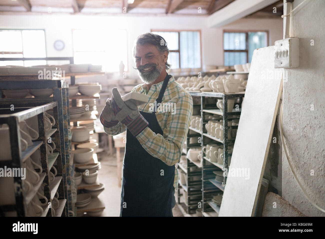 Male potter holding craft product in pottery workshop Stock Photo - Alamy
