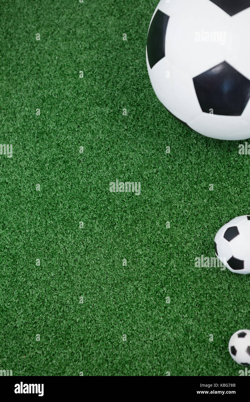 Closeup of various size of footballs on artificial grass Stock Photo