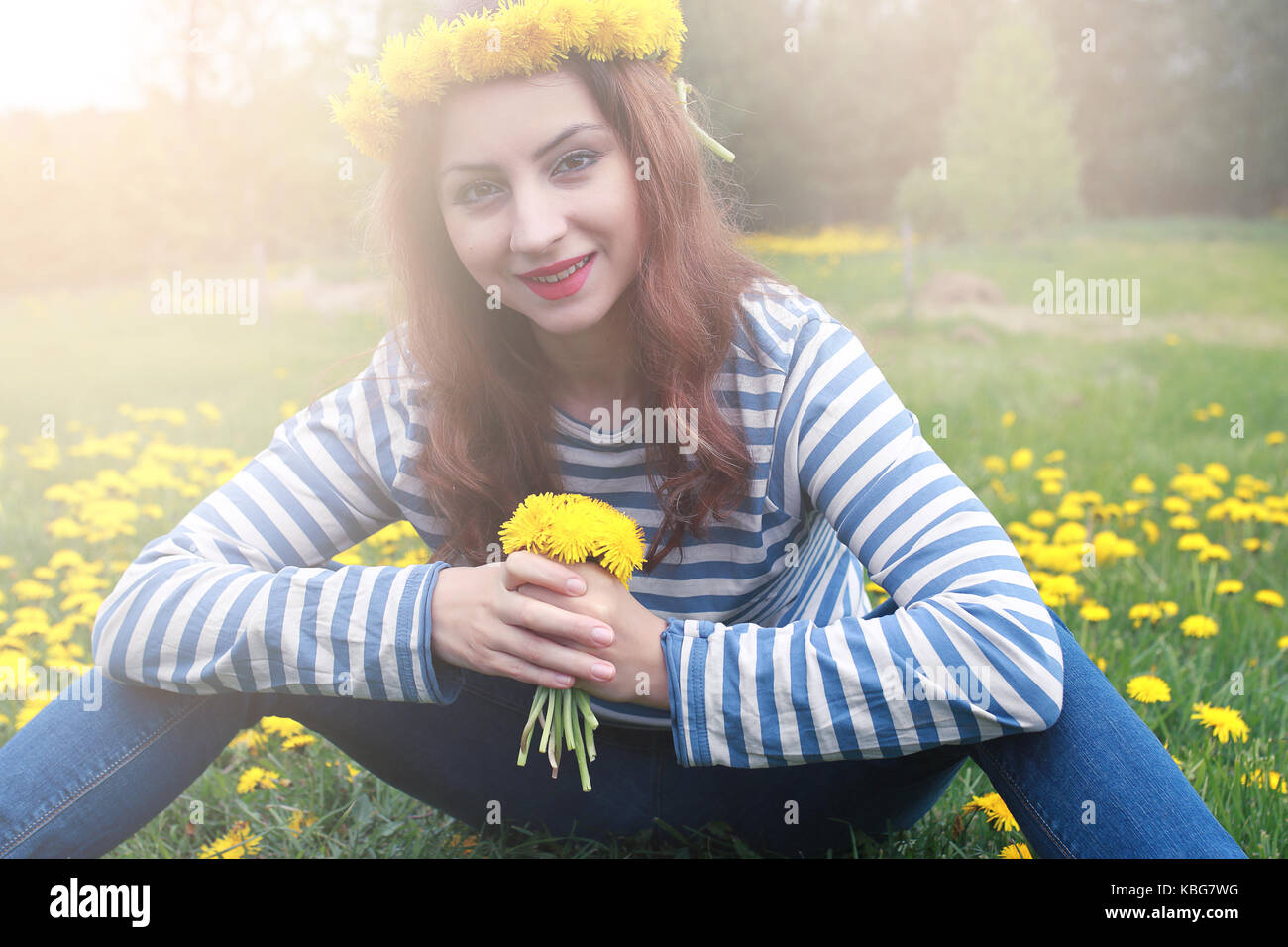 girl resting on a sunny day in meadow of yellow dandelions Stock Photo ...