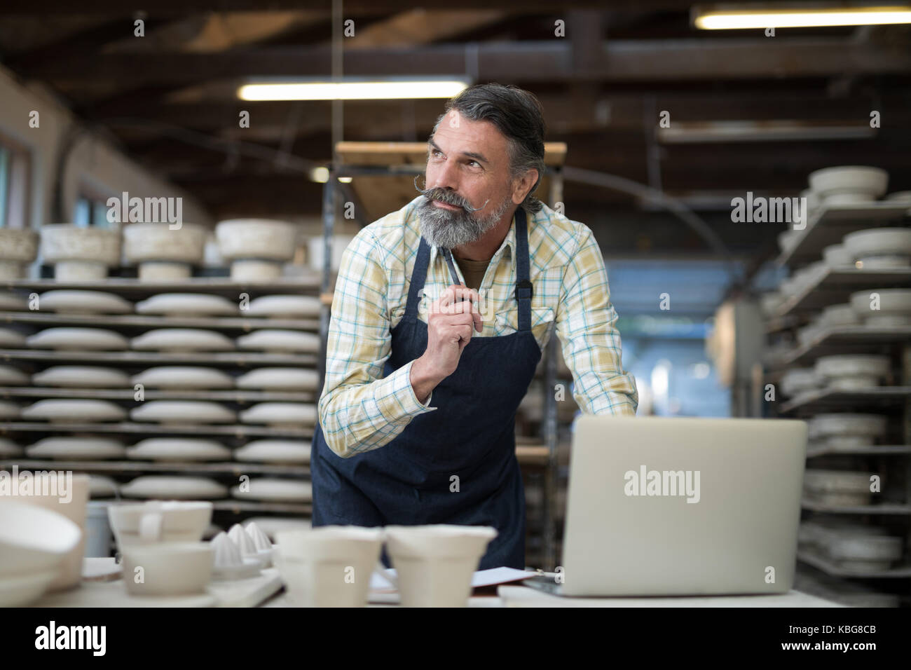 Thoughtful male potter working at worktop in pottery workshop Stock ...