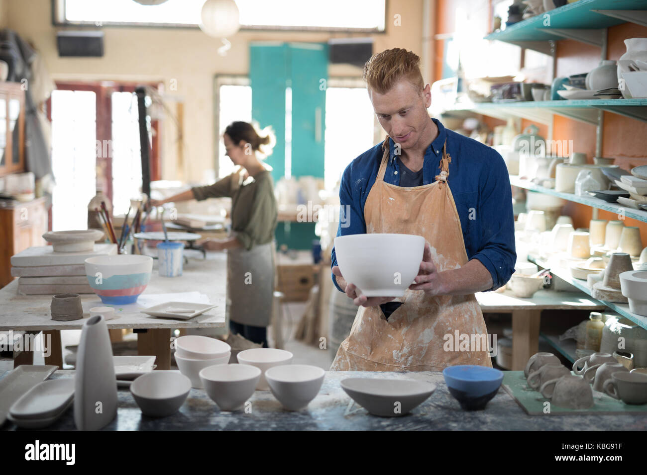 Male potter checking ceramic bowl in pottery workshop Stock Photo - Alamy