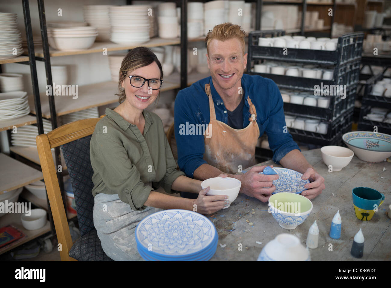 Male and female potter decorating bowl in pottery workshop Stock Photo ...