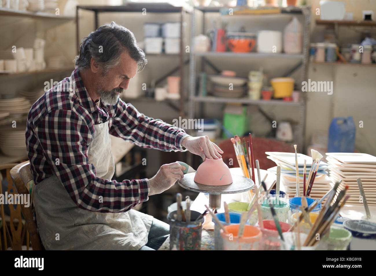 Male potter painting bowl in pottery workshop Stock Photo - Alamy
