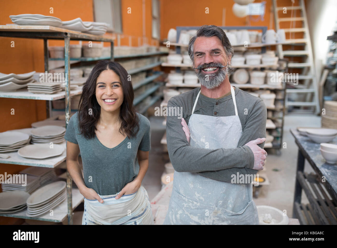 Portrait of male and female potter standing in pottery workshop Stock ...