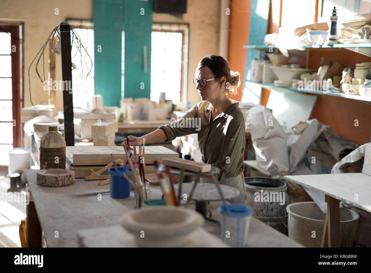 Female potter working at worktop in pottery workshop Stock Photo - Alamy