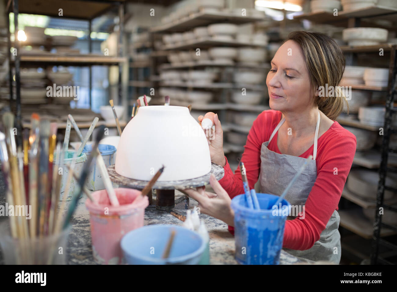 Female potter decorating bowl in pottery workshop Stock Photo - Alamy