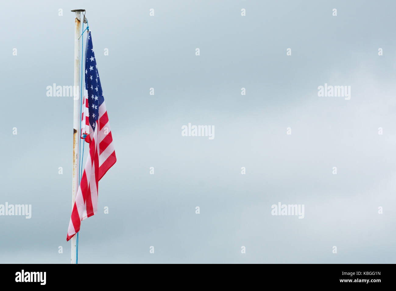 The American flag lays still on a flagpole Stock Photo