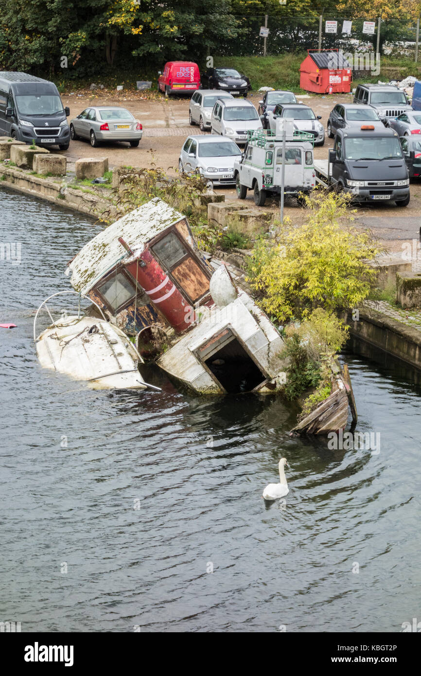 A sunken boat as viewed from the suspension bridge to Port Hampton's Platts Eyot in Hampton, London, UK Stock Photo