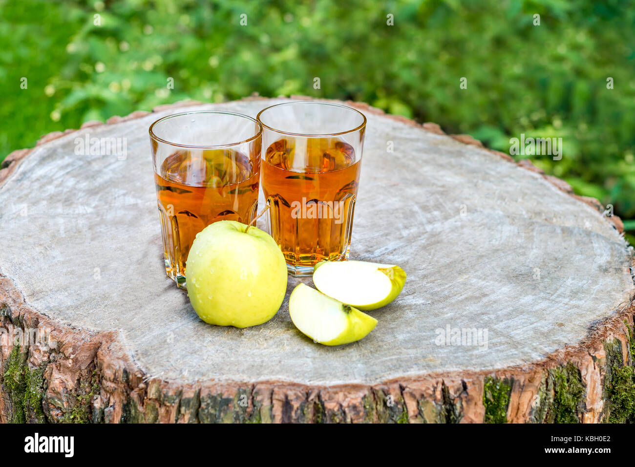 The two glasses of fresh apple juice with apples fruit on a wooden ...