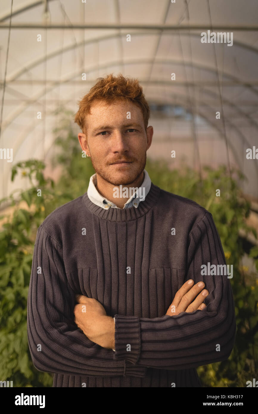 Portrait of farmer standing with arms crossed in greenhouse Stock Photo ...