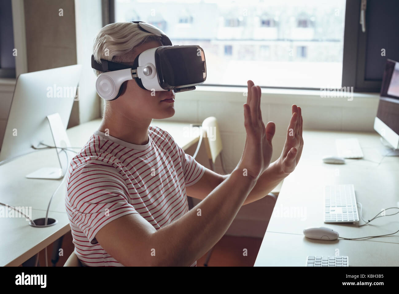 Man using virtual reality headset in office Stock Photo - Alamy