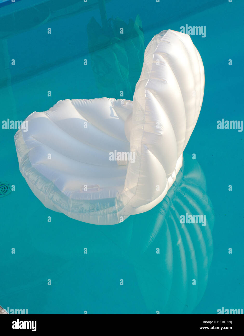 Shell shaped air mattress in the pool with small ring box Stock Photo
