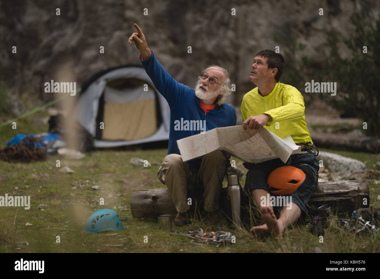 Friends having discussion over map while camping Stock Photo