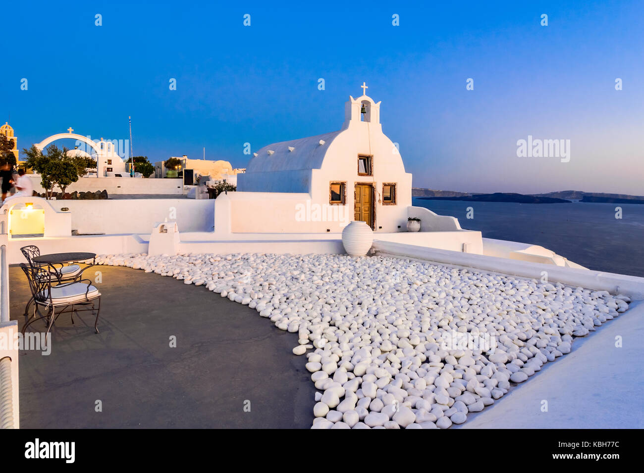 Oia town, Santorini island, Greece at sunset. Traditional and famous white churches  over the Caldera, Aegean sea. Stock Photo