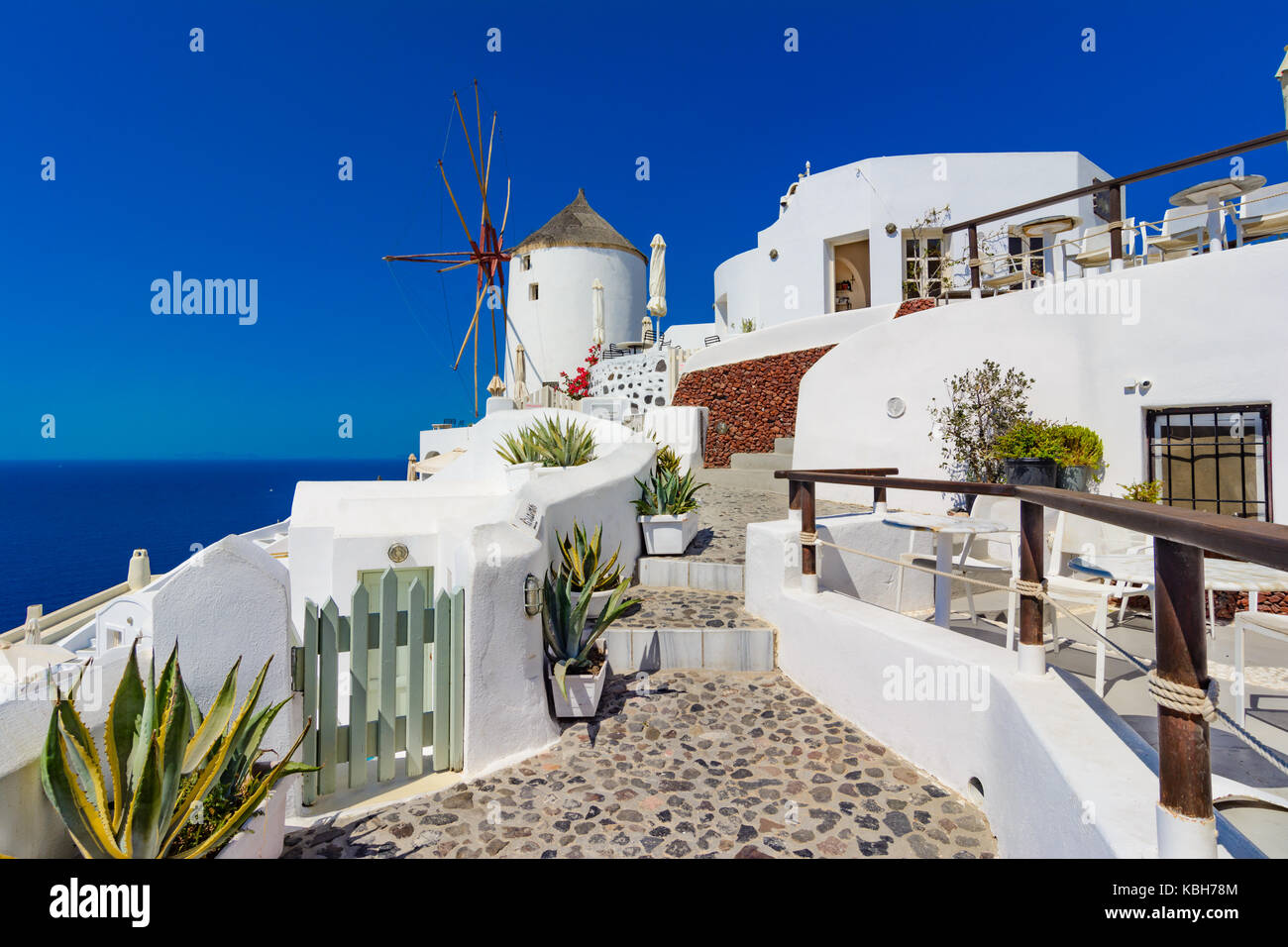 Oia town, Santorini island, Greece. Famous windmills on cliff, cobled streets and white houses over the Caldera, Aegean sea. Stock Photo