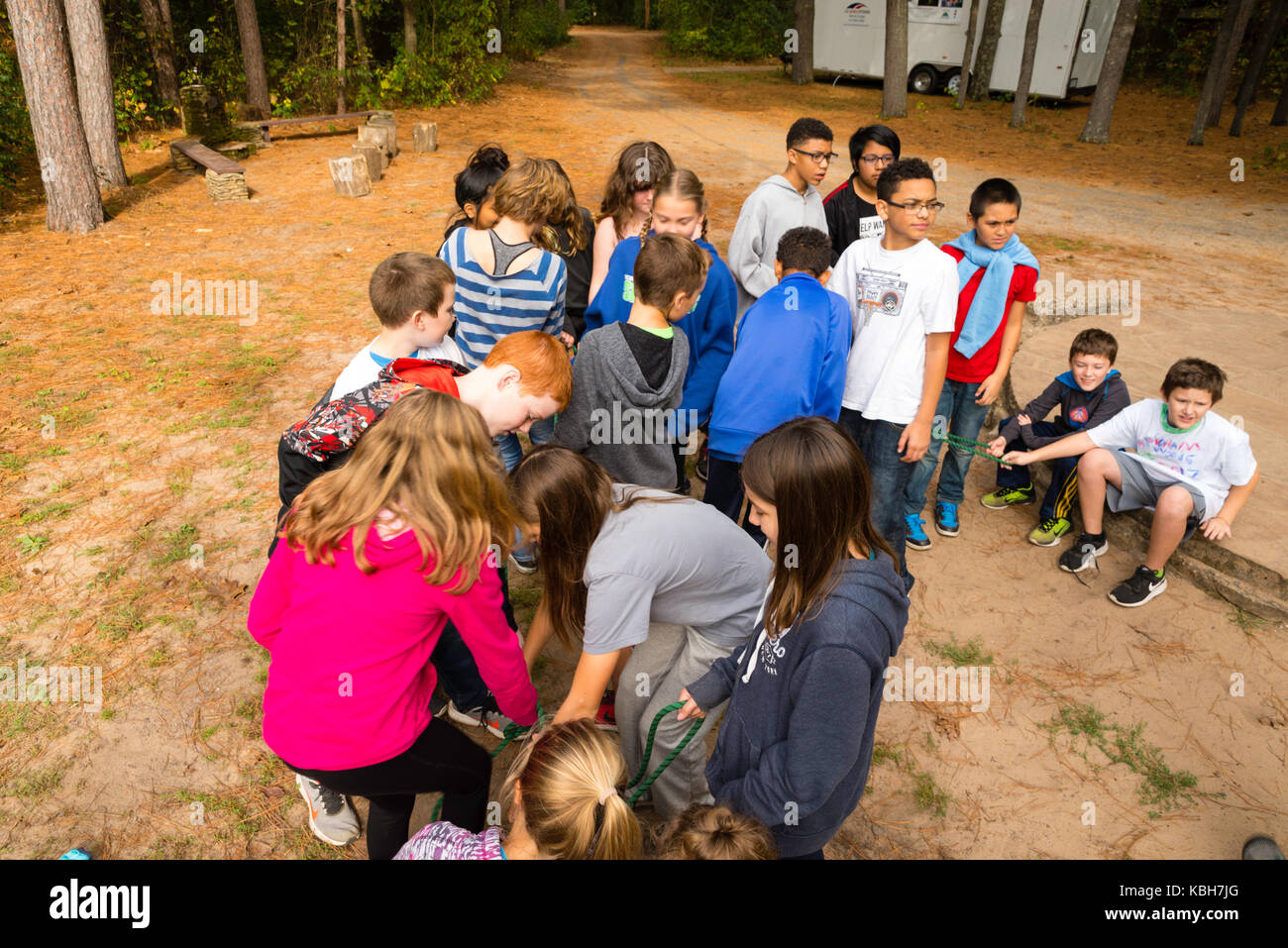 Kids use a rope to learn team building skills and other environmental ...