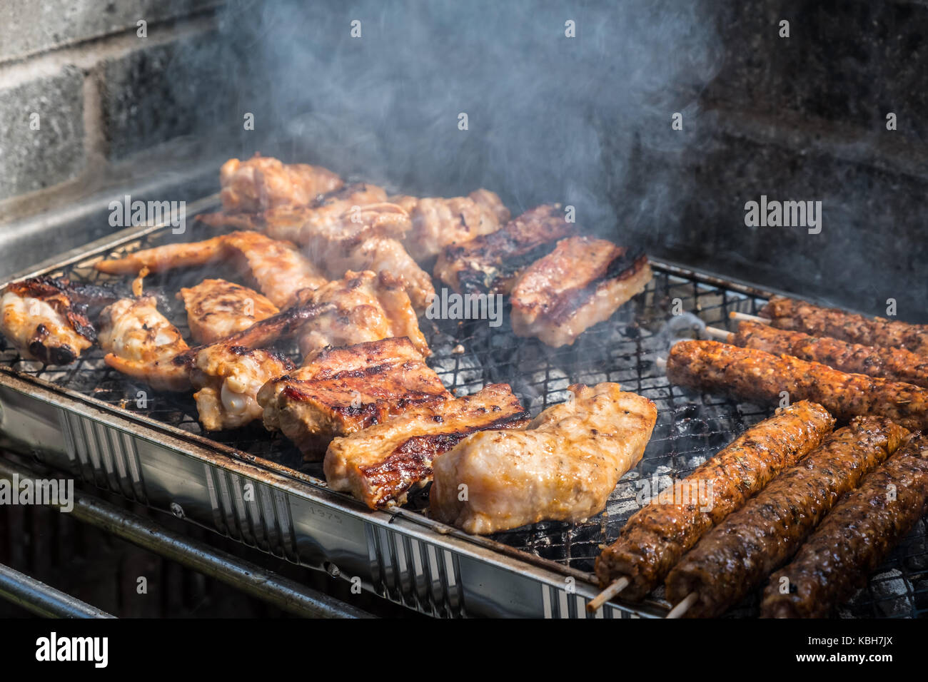 Variety of meat are cooked on a disposable BBQ set Stock Photo
