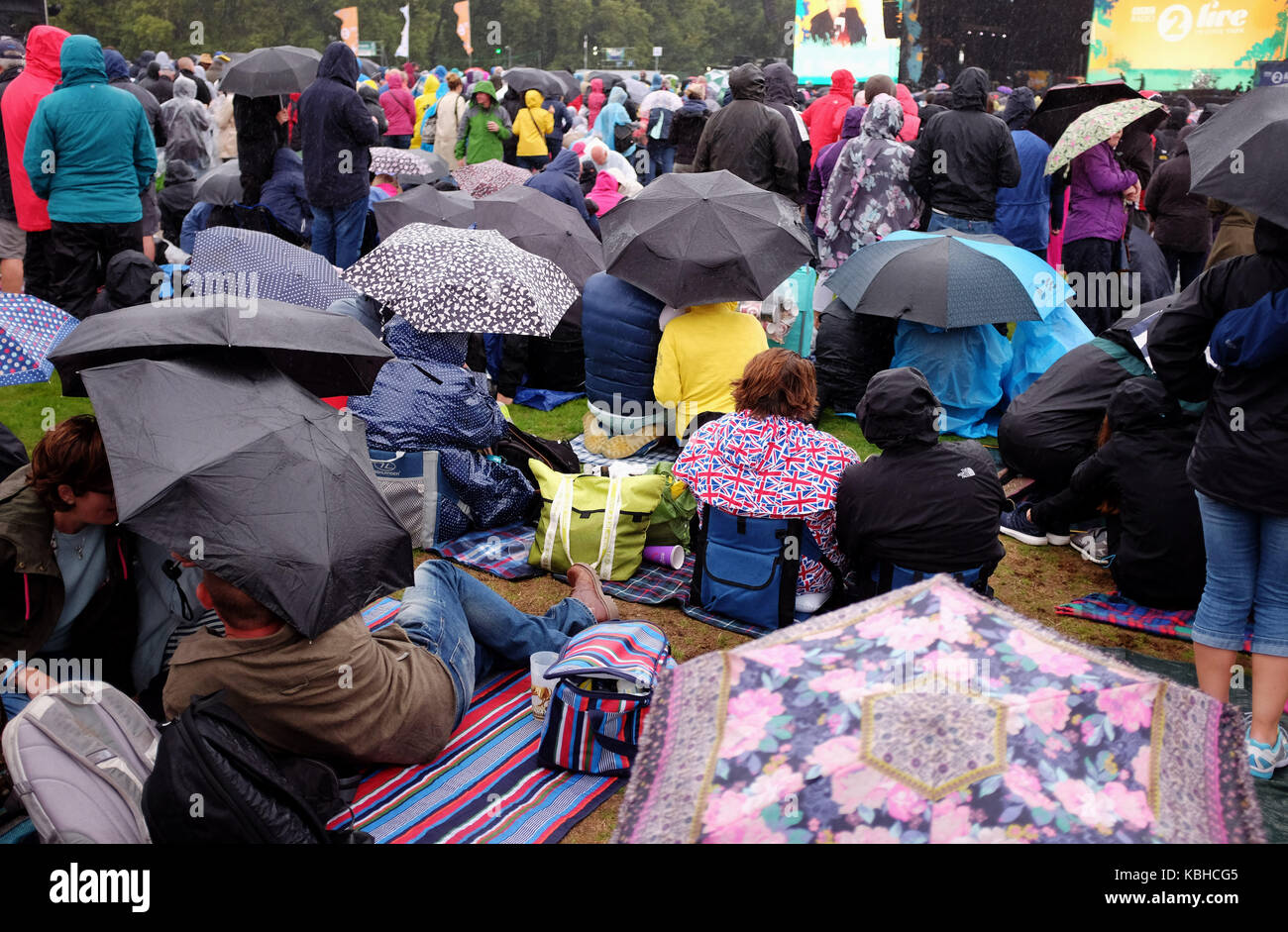 Taking shelter in the rain at Radio 2 Festival in a Day picnic at Hyde Park  London 2017 Stock Photo - Alamy
