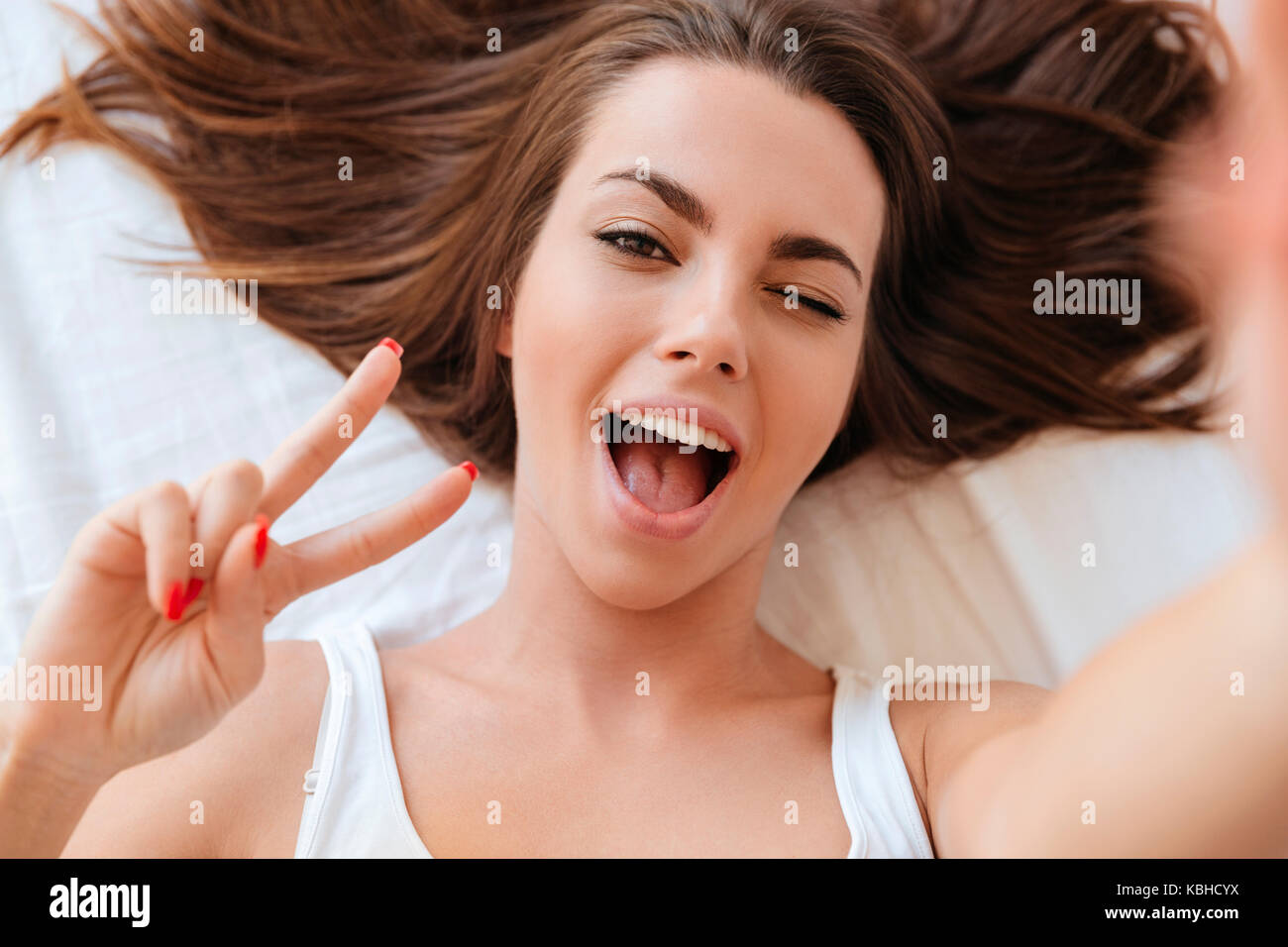 Close up portrait of a pretty young woman winking while making a selfie ...