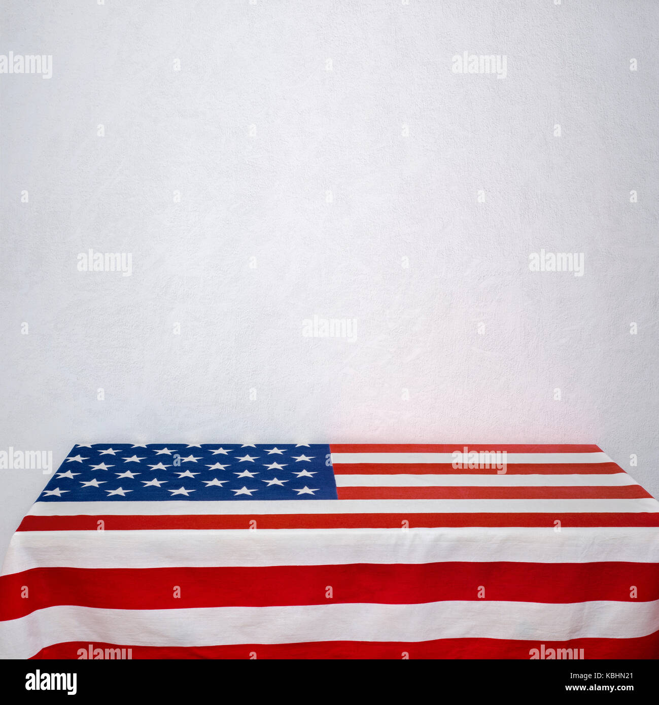 American flag table near the white stucco wall Stock Photo
