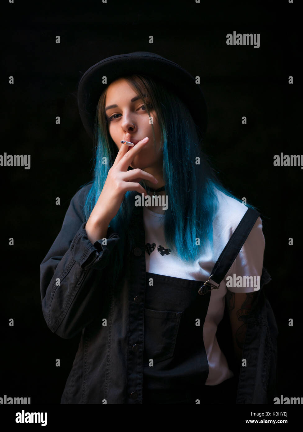 Emo girl smoking cigarette.Street punk or hipster woman with blue ...