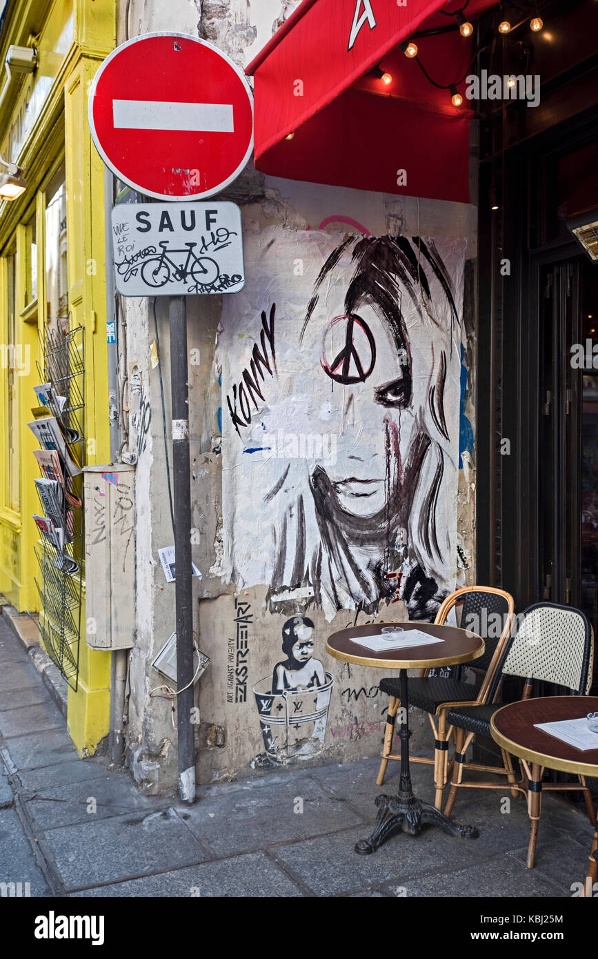 Graffiti on a wall by a cafe on the rue de Buci in the Latin Quarter of Paris. Stock Photo