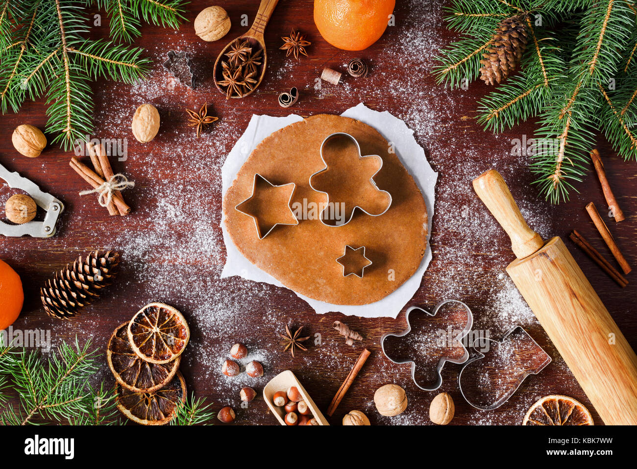 Gingerbread cookies preparation. Christmas cookies baking on wooden background. Christmas decorations, gingerbread cookie dough, cookie cutters, spice Stock Photo