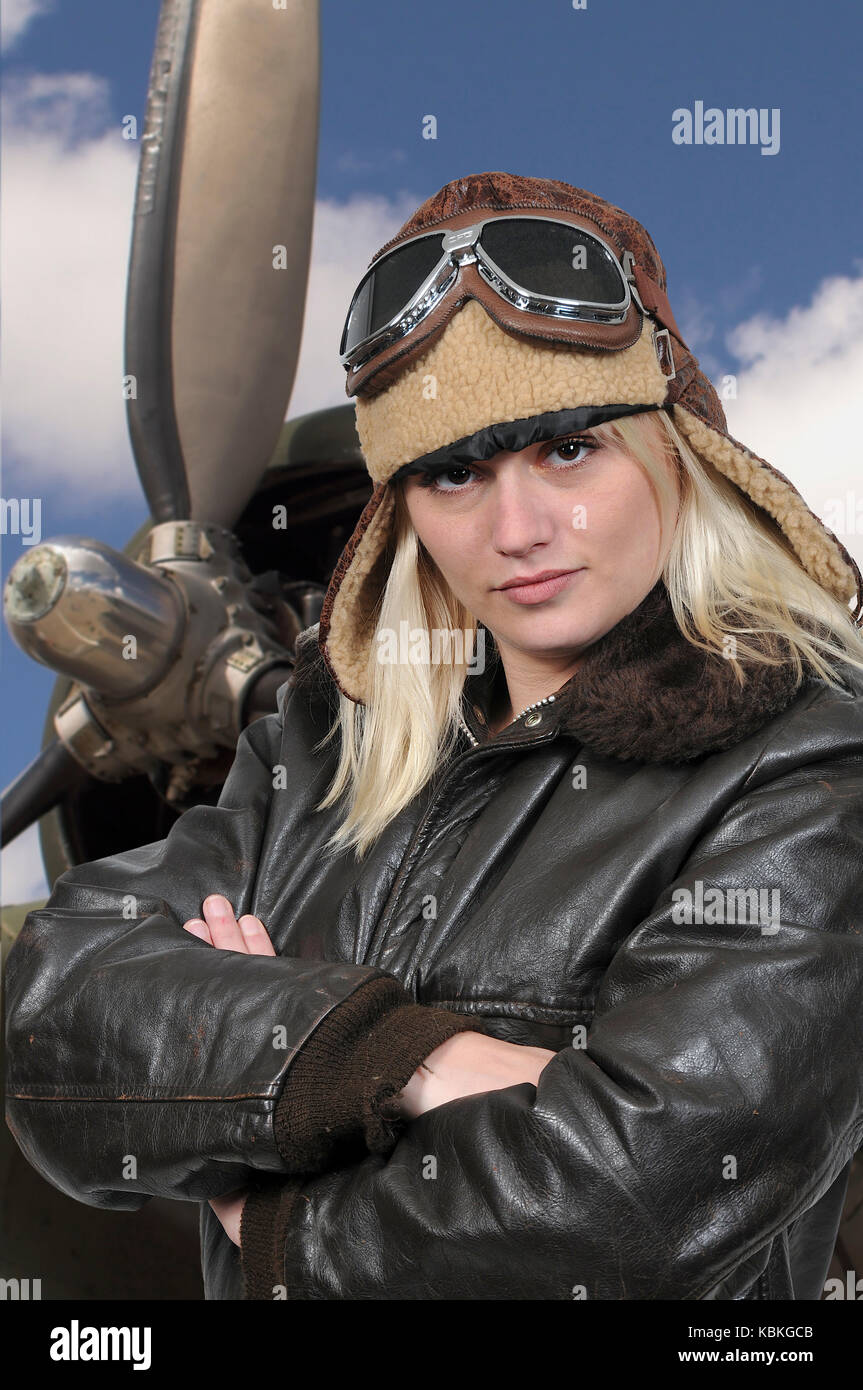 Woman pilot wearing vintage pilot helmet flight jacket and goggles Stock Photo