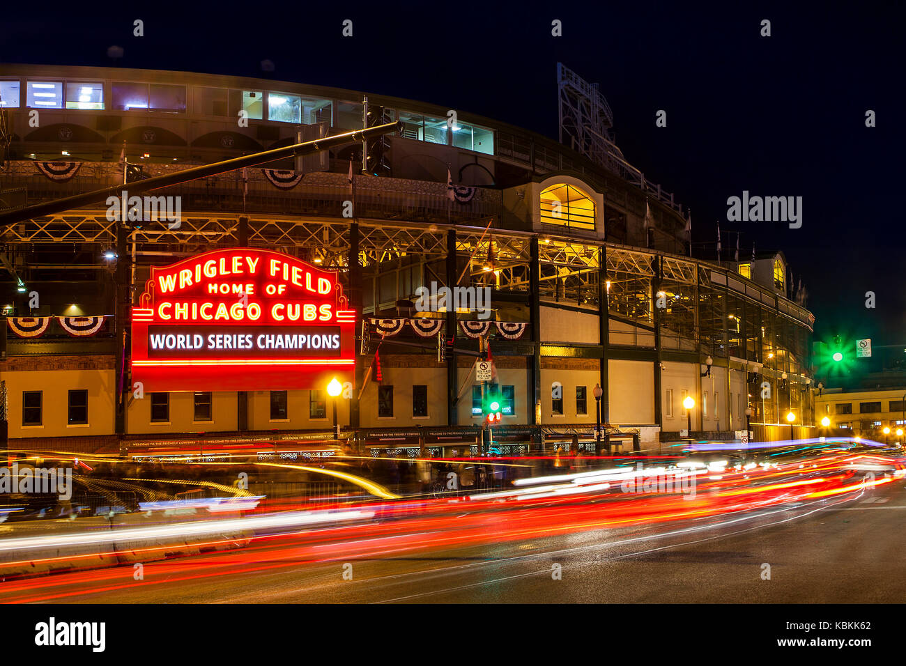 Traffic streaming past Chicago's Wrigley Field and entry sign announcing the Chicago Cubs as World Series Champions Stock Photo