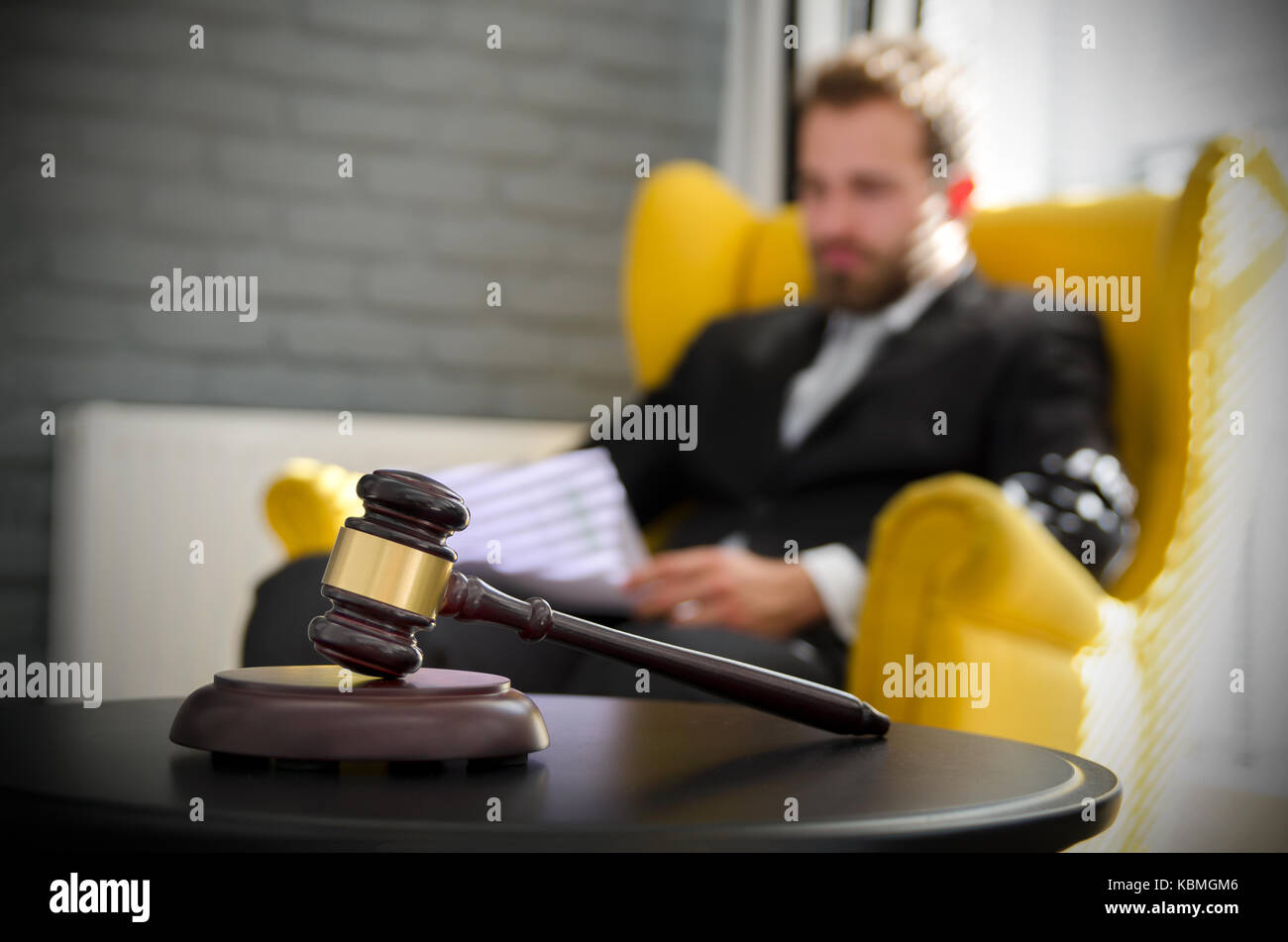Wooden gavel, working lawyer in background. attorney business judgment justice suite analyzing authority background concept Stock Photo