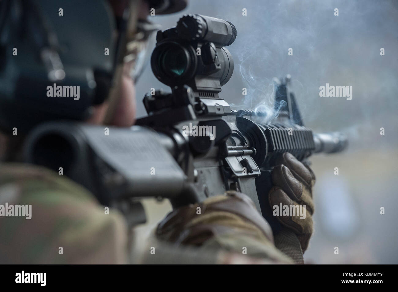 Smoke emanates from U.S. Air Force Senior Airman’s M4 carbine during live-fire sustainment training Stock Photo