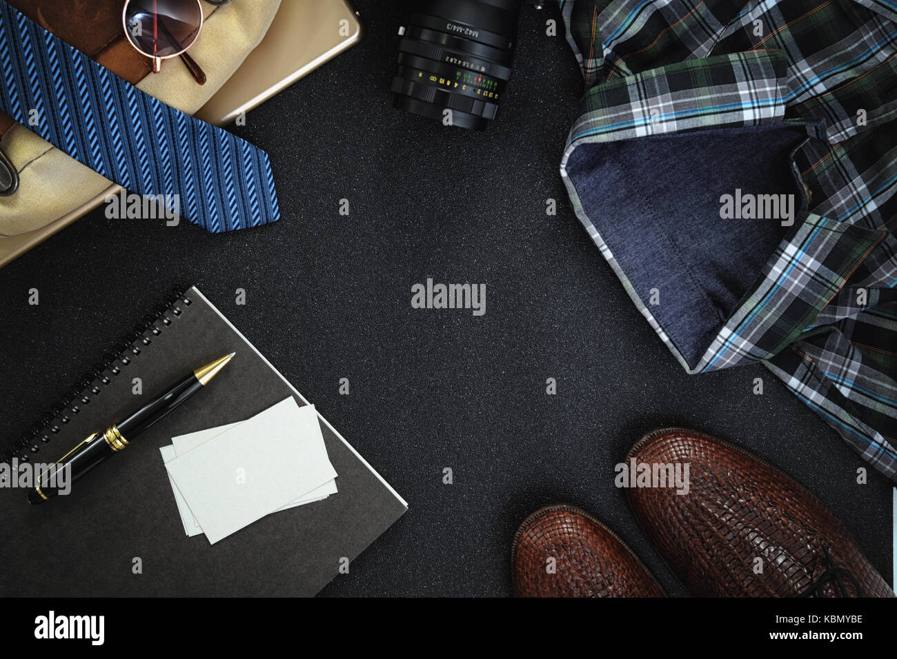 Men Clothing and Accessories shoes, glasses, shirt and name card on dark background. Top view with copy space Stock Photo