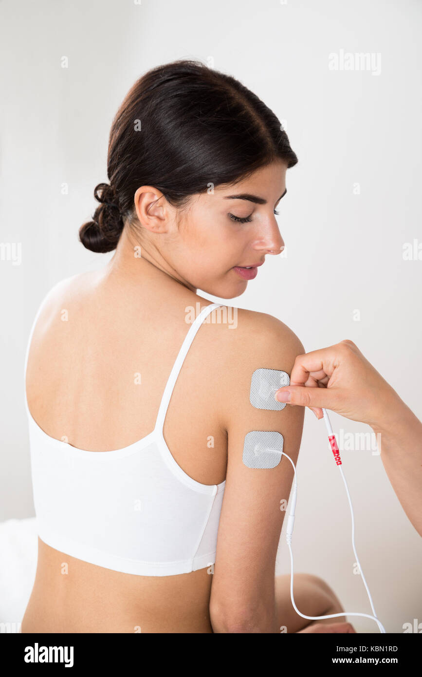 Close-up Of Young Woman Getting Electrodes Therapy On Hand Stock Photo