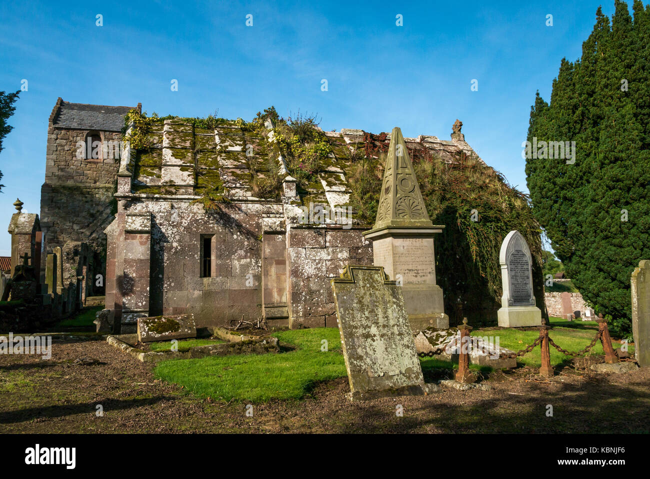 Gravestones, tall dovecote and old family tomb in Stenton Parish Church graveyard, Stenton, East Lothian, Scotland, UK Stock Photo