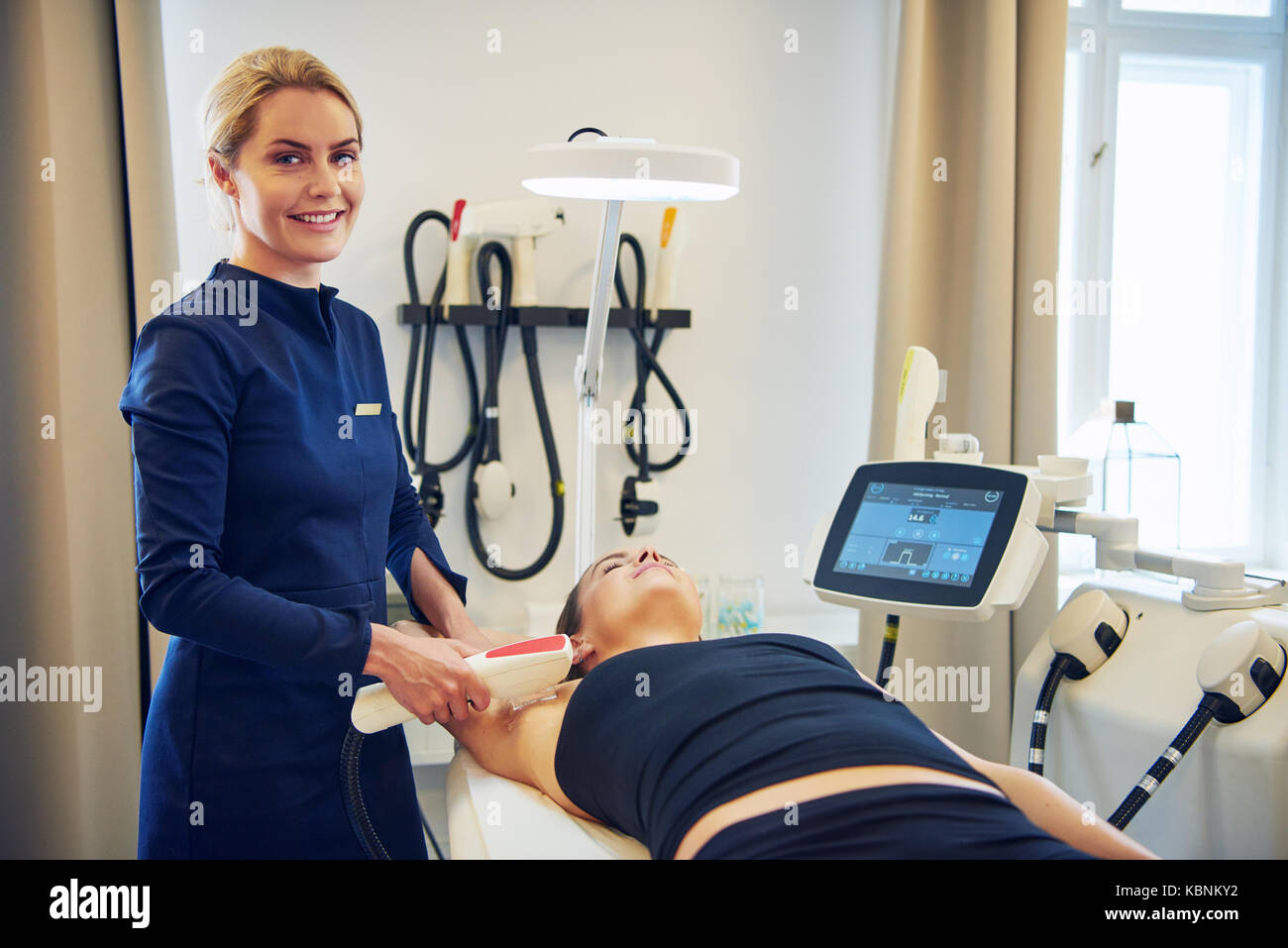 Smiling young female beautician performing an electrolysis hair removal  procedure on the underarm of a woman lying on a table in a beauty clinic  Stock Photo - Alamy