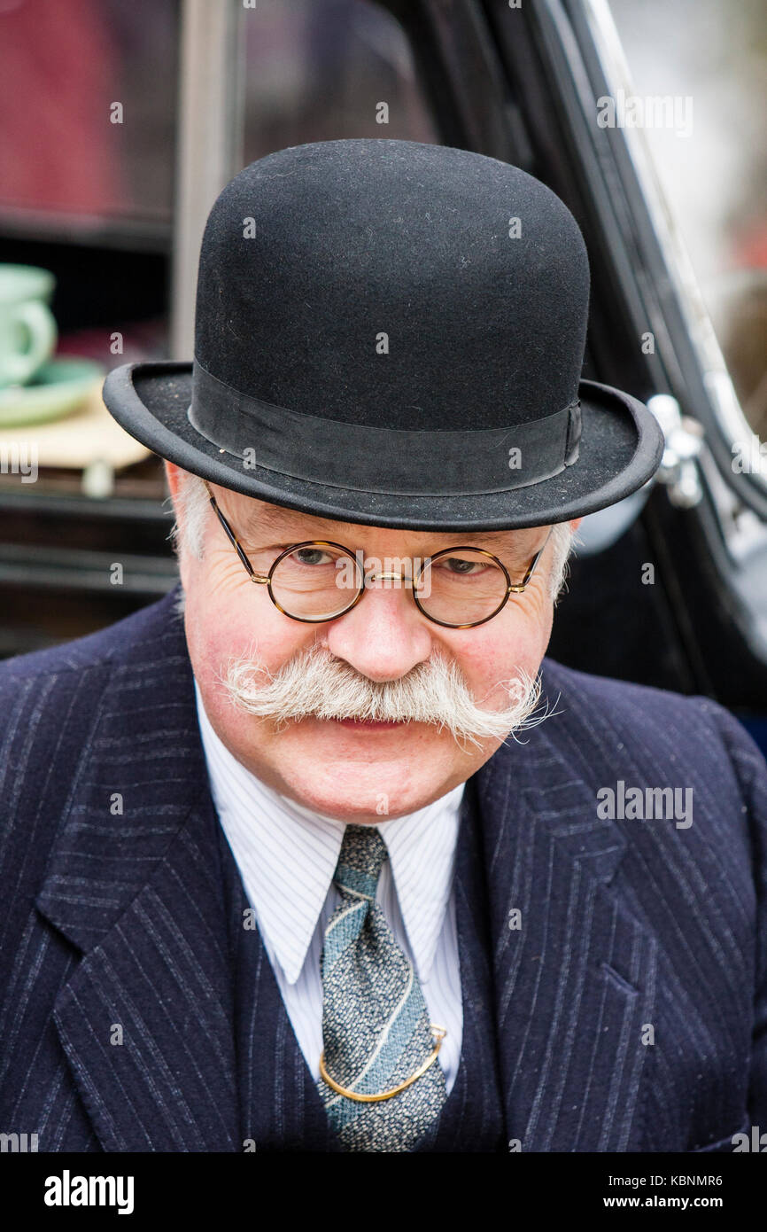 England, Chatham. Elderly man, grey moustache and glasses, wearing black bowler hat. Facing, eye-contact. Circa 1940s re-enactor. Head and shoulders. Stock Photo