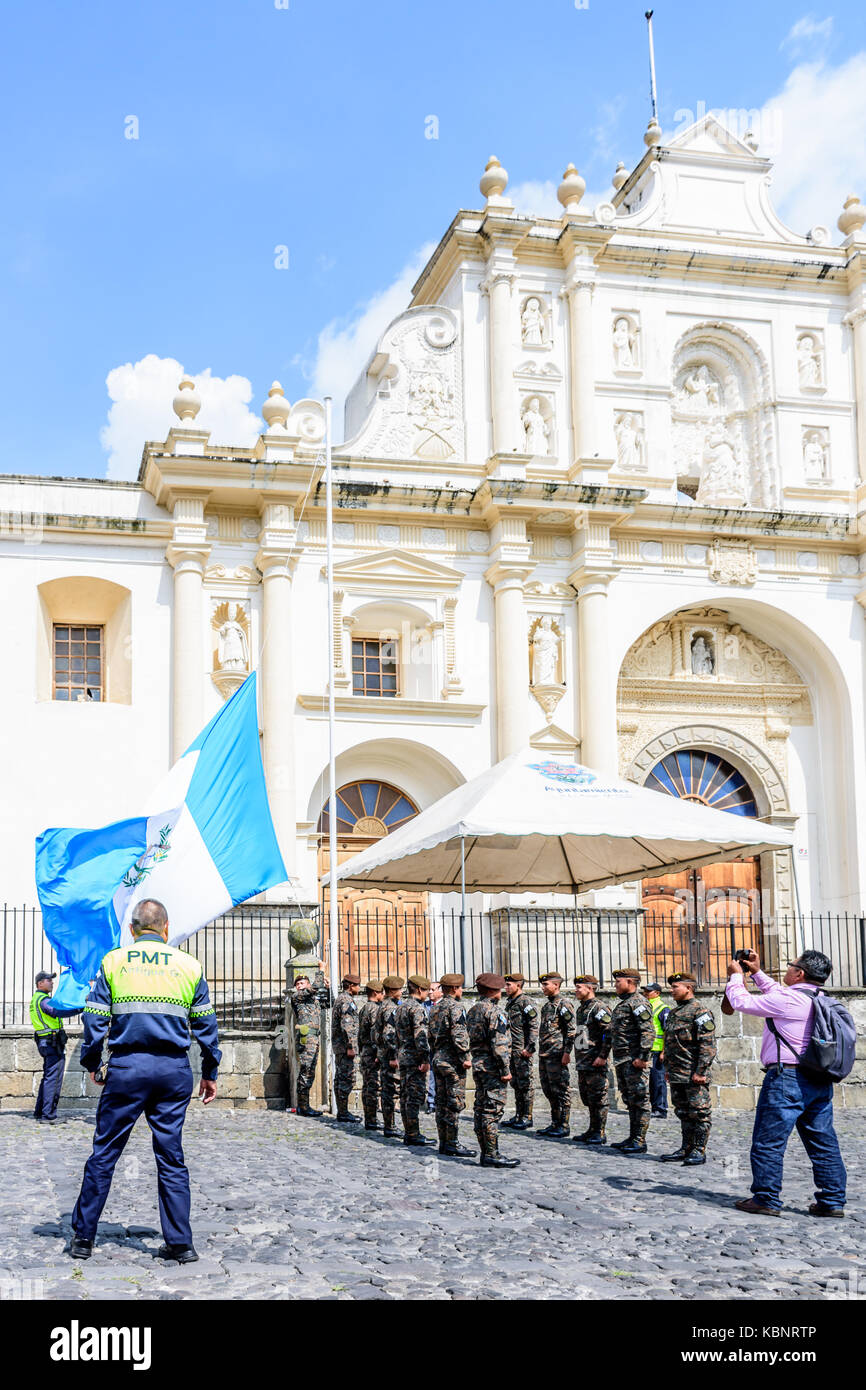 Antigua, Guatemala - September 15, 2017: Soldiers lower Guatemalan flag alongside Mayor of Antigua outside cathedral on Guatemala's Independence Day. Stock Photo