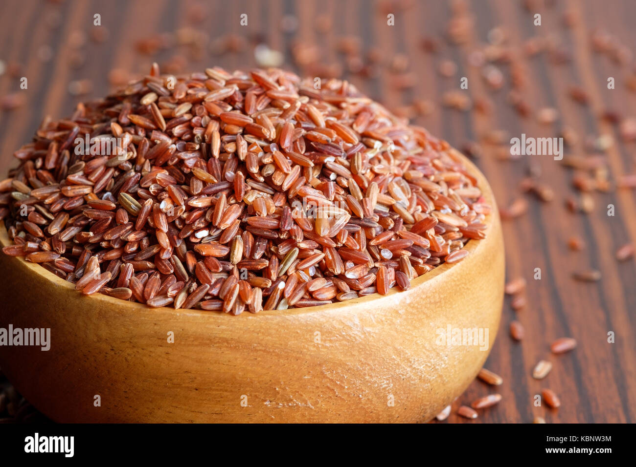 Red rice in wooden bowl Stock Photo