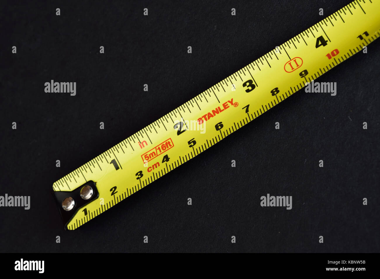 https://c8.alamy.com/comp/KBNW5B/yellow-stanley-steel-tape-measure-on-black-background-KBNW5B.jpg